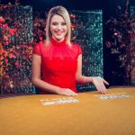 Female live dealer at an online casino live Baccarat table.