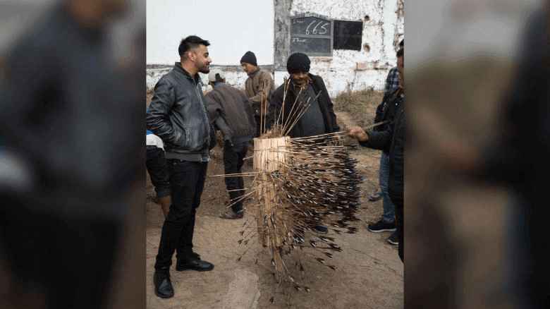 men looking at Teer target full with arrows.