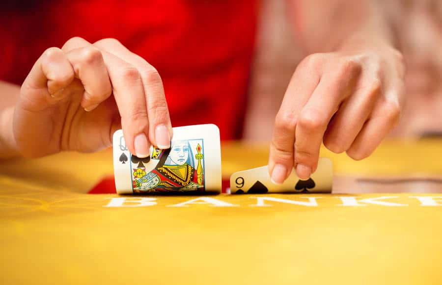 Baccarat dealer squeezing cards