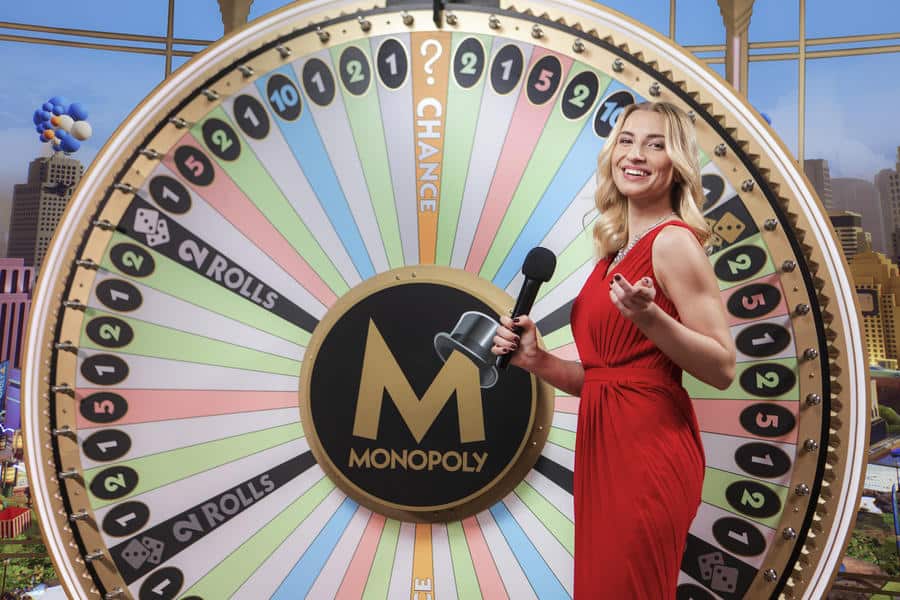 the monopoly live game show host and the game's lucky wheel.