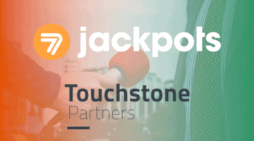 hand holding microphone. sevenjackpots and touchstone partners logos