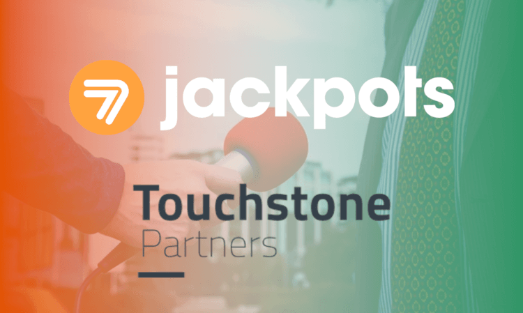 hand holding microphone. sevenjackpots and touchstone partners logos
