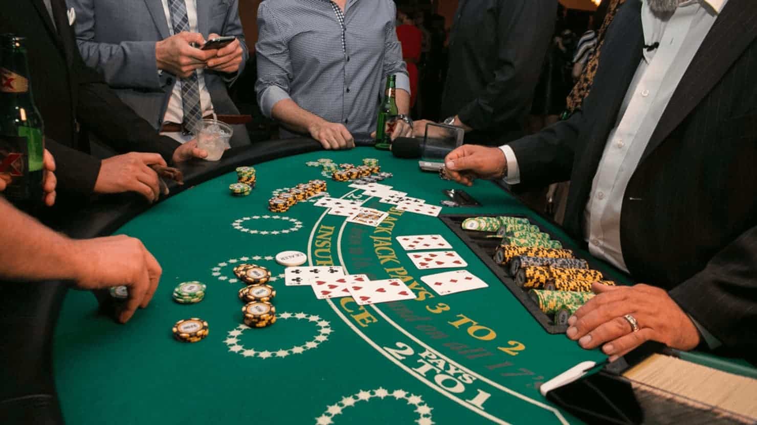 Busy blackjack table during a game round with players and the dealer.