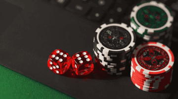 imagem de fichas e dados de cassino sobre um notebook.